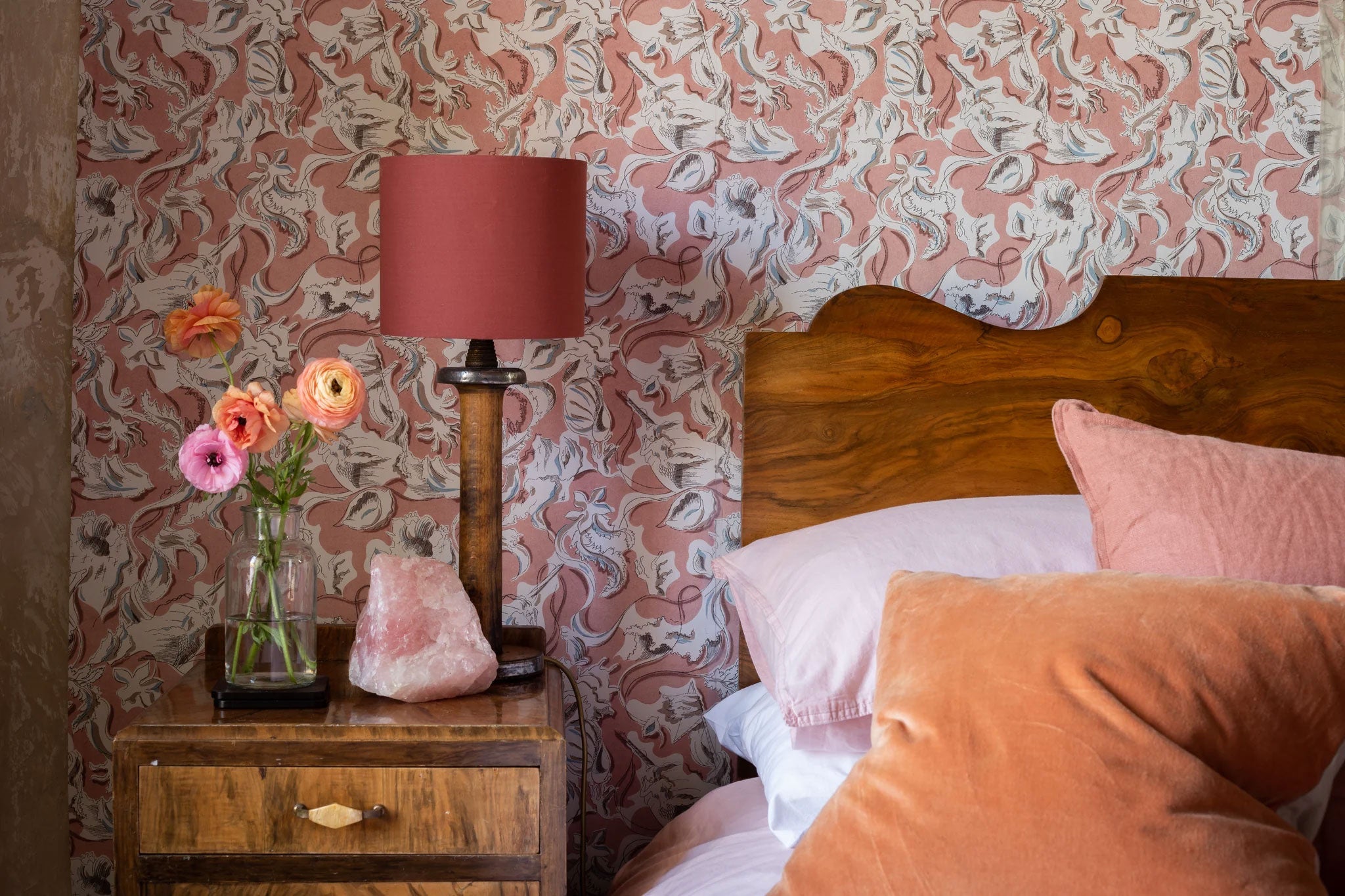 A wallpapered bedroom in dusty pink and terracotta — the domestic register of The May Edit at Söstter, a curation of five independent founder-run brands.