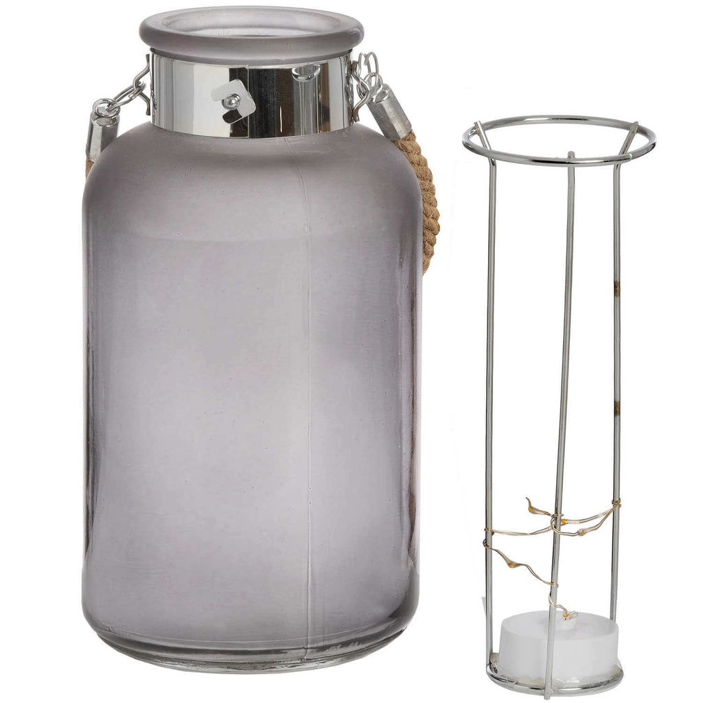 Frosted grey glass lantern with star-like LED glow, rope handle, modern rustic design for indoor or outdoor ambiance. by sostter at brixbailey.com
