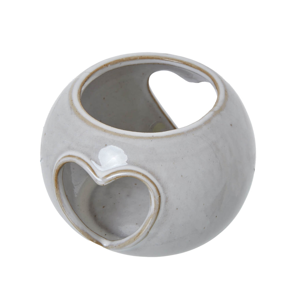 White ceramic tealight holder with heart-shaped cutouts, creating warm ambient light patterns by sostter at brixbailey.com