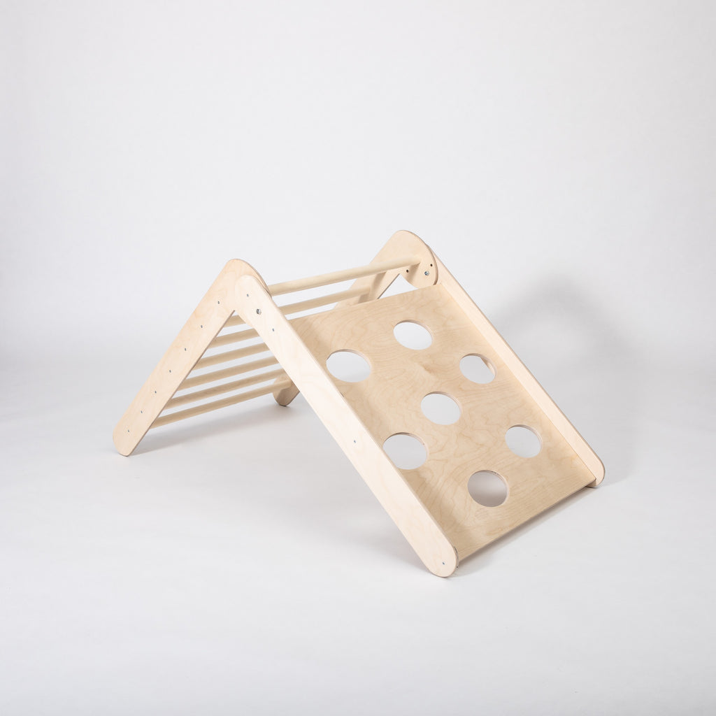 toddler climbing foldable montessori triangle in a sunlit playroom, showcasing adjustable slopes for active play