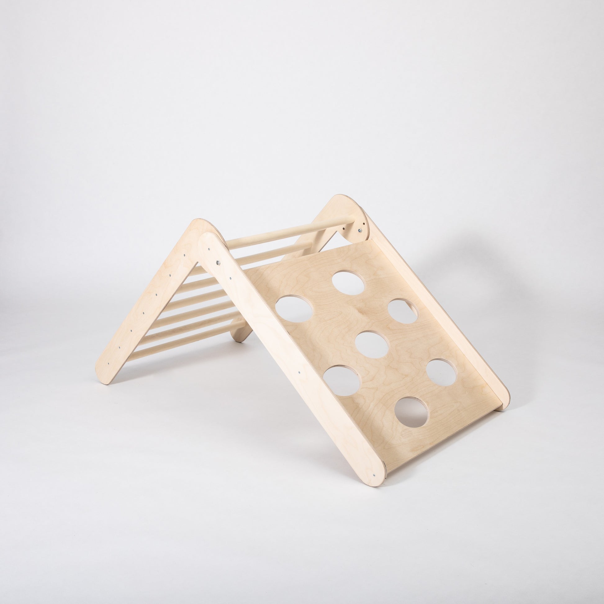 toddler climbing foldable montessori triangle in a sunlit playroom, showcasing adjustable slopes for active play