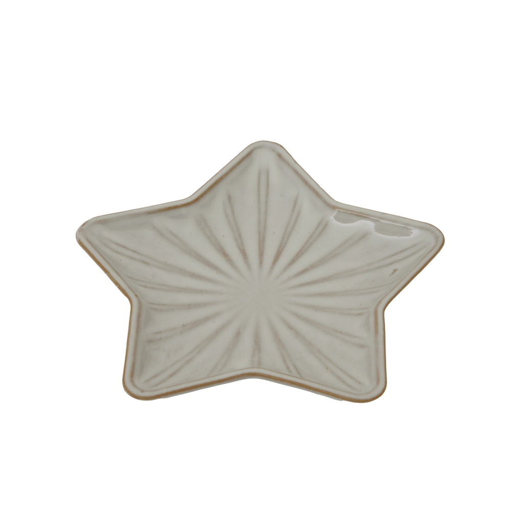 bold white ceramic star dish casting sharp geometric shadows on a dark surface