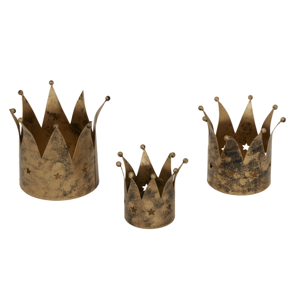 a playful antique gold crown tealight holder casting fun, dancing shadows on a winter table