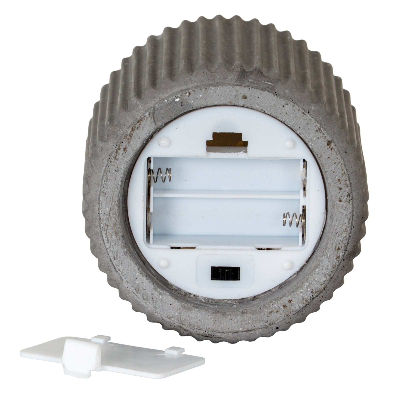 large grey ribbed led candle glowing on a kitchen countertop next to a recipe book