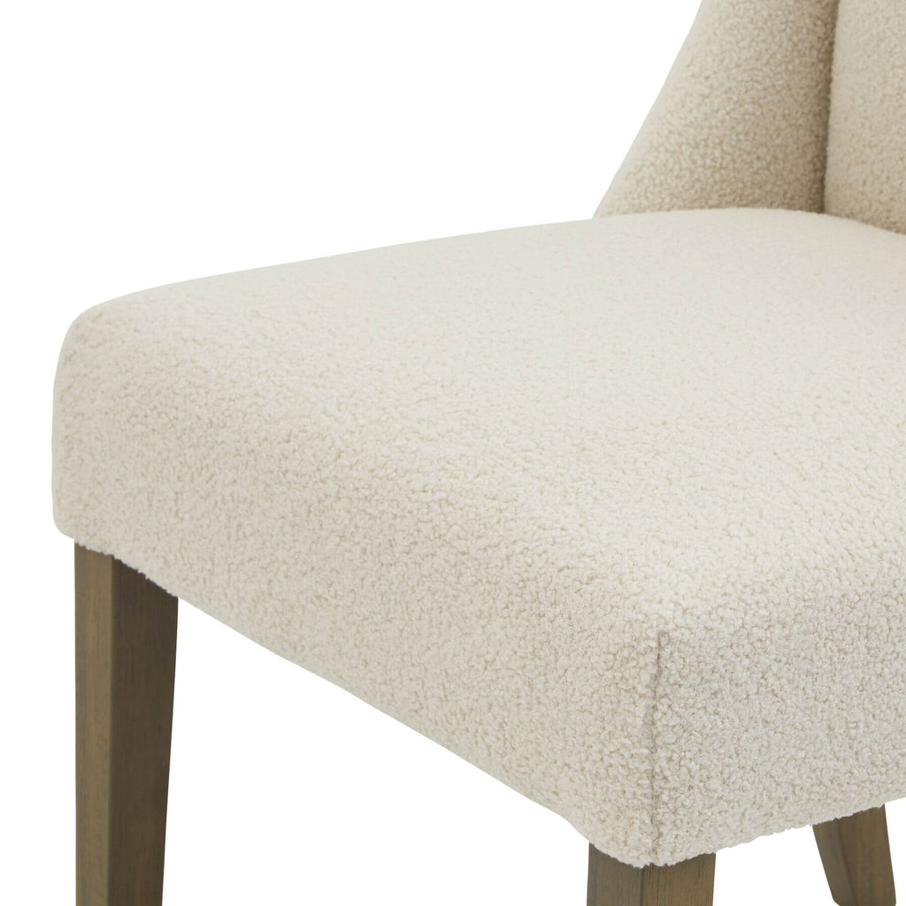 Cream bouclÃ© dining chair with rubberwood frame, modern silhouette, and quiet luxury aesthetic by Sostter at brixbailey.com
