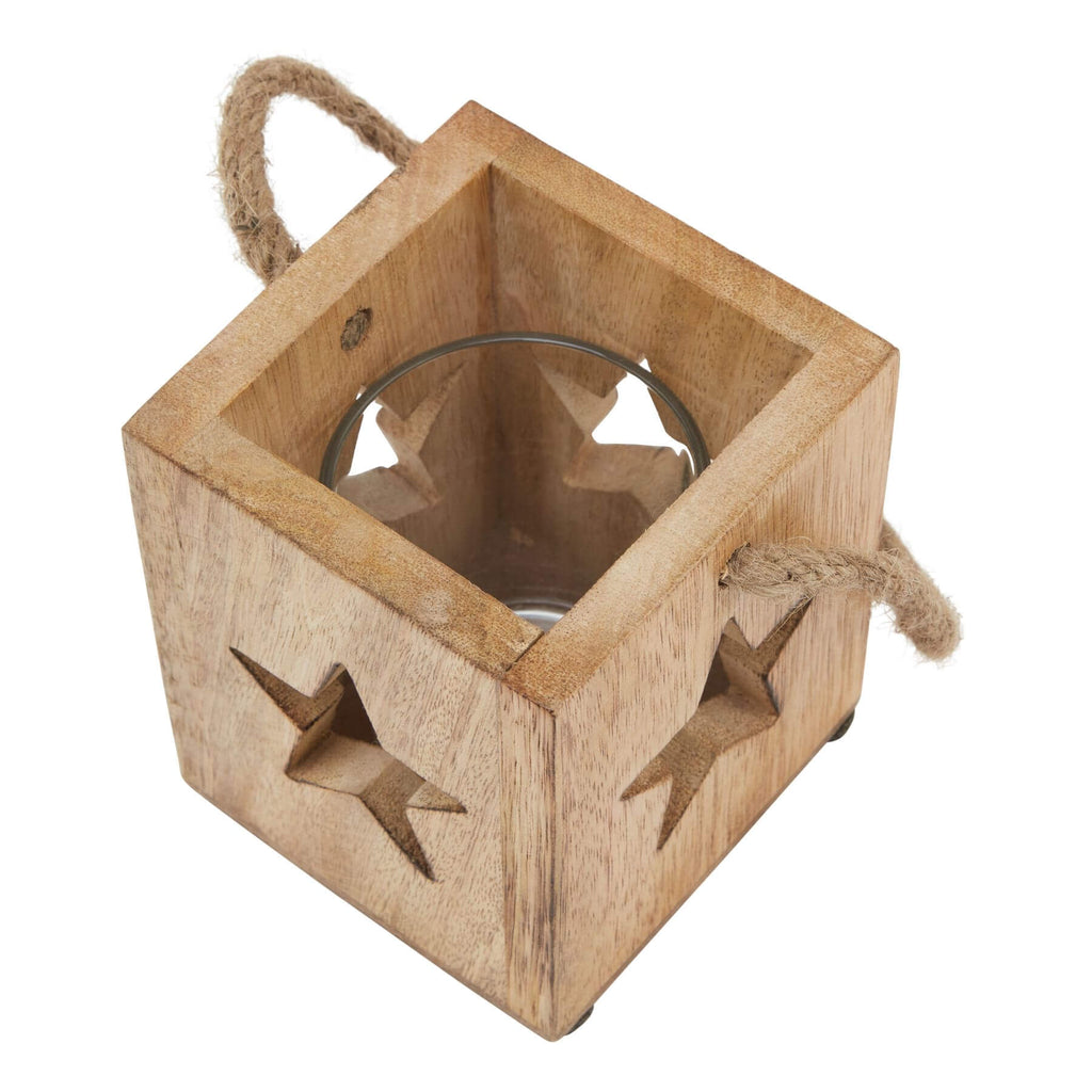a rustic wooden star tealight holder casting a soft, warm glow on a cozy mantlepiece