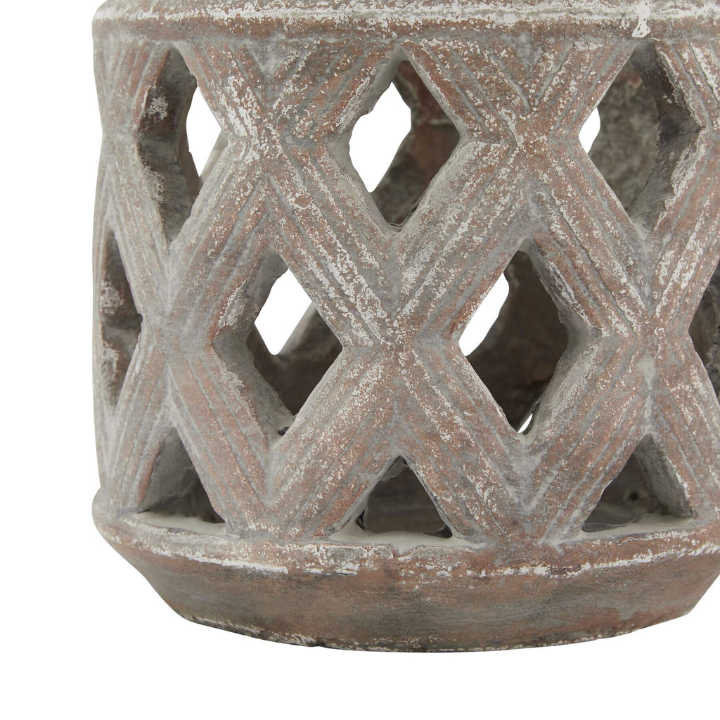 Brown ceramic lattice lantern with geometric diamond-cut patterns, casting mesmerizing light displays on tabletop. by Sostter at brixbailey.com