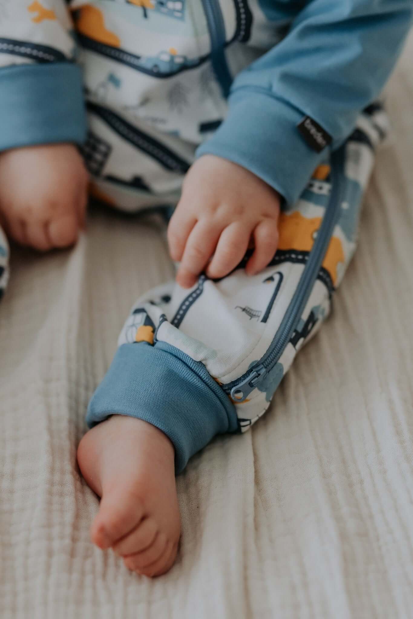 elegant baby sleepsuit in a soft cotton blend with refined ribbed cuffs and a two-way zipper