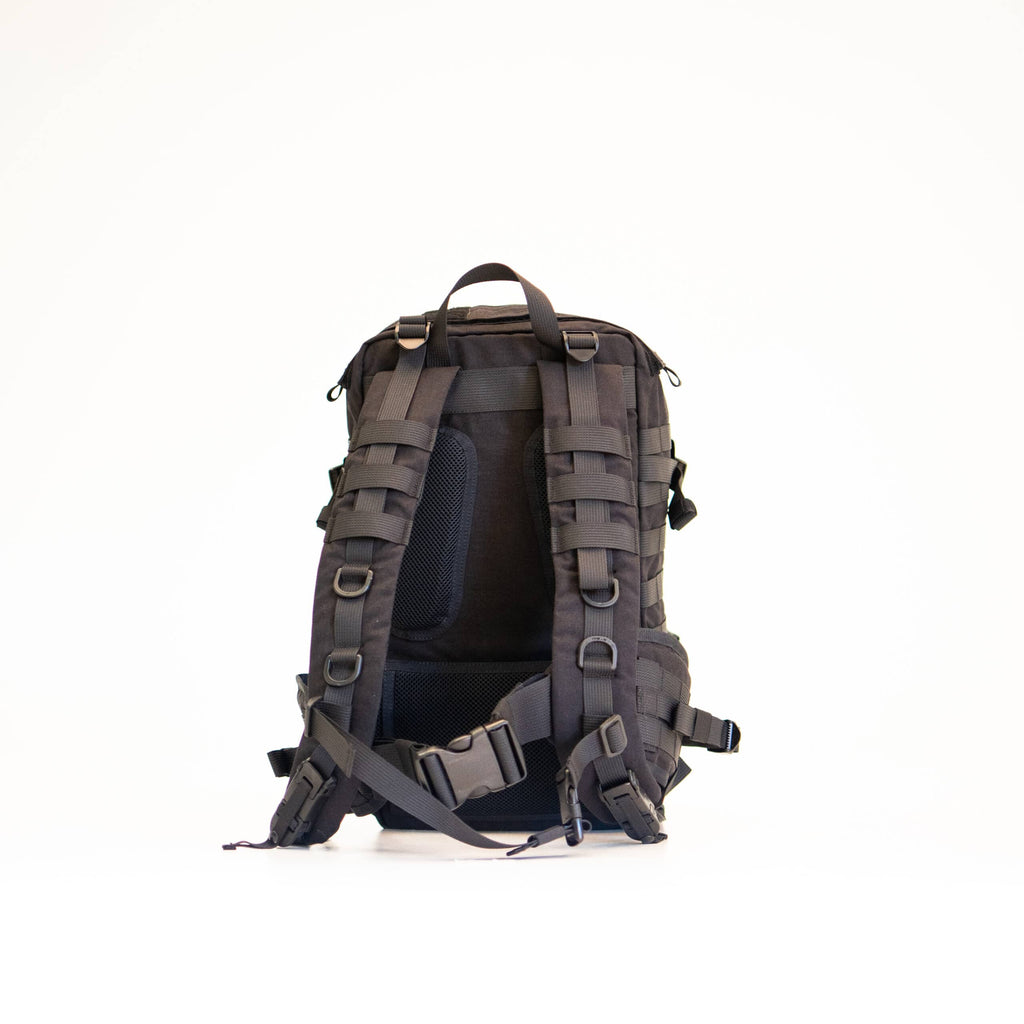 playful side view of the black galvi-linda backpack with molle straps in golden hour light