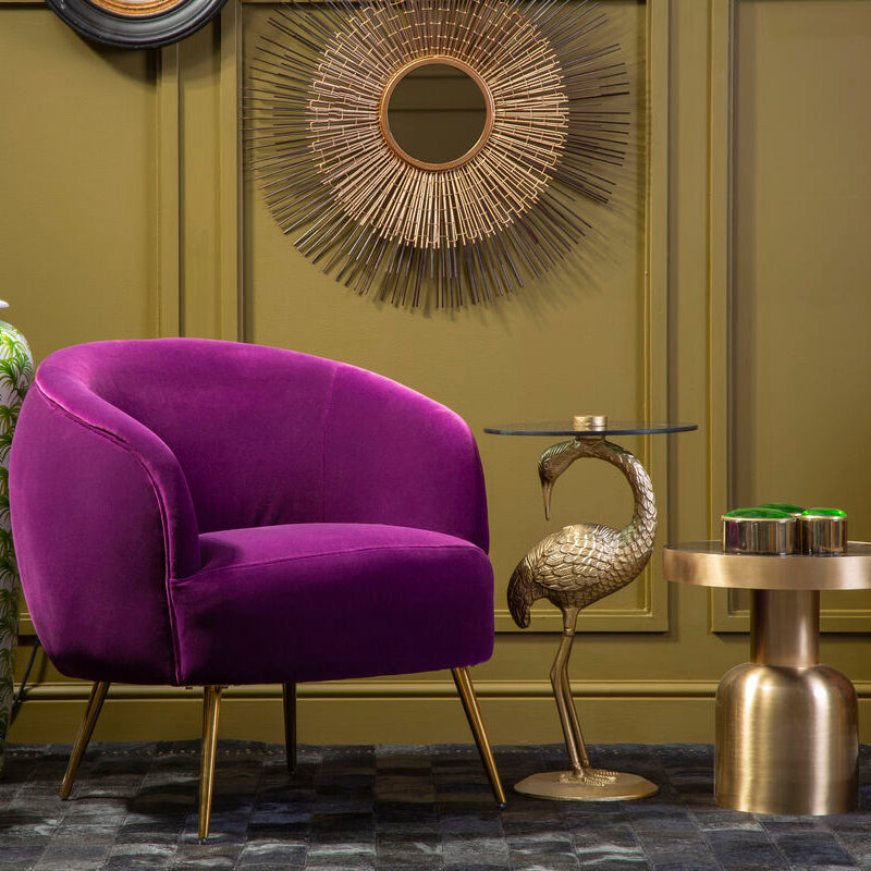 Purple armchair in a stylish room with gold accents and decorative wall art. Available at Sostter