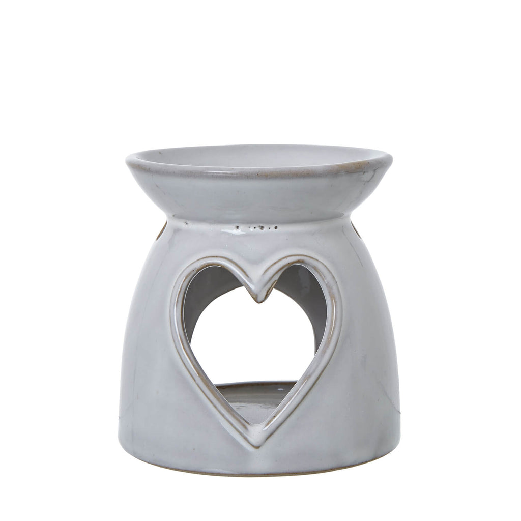 White ceramic tealight holder with heart cut-outs casting delicate light patterns, perfect for cozy home decor. by sostter at brixbailey.com