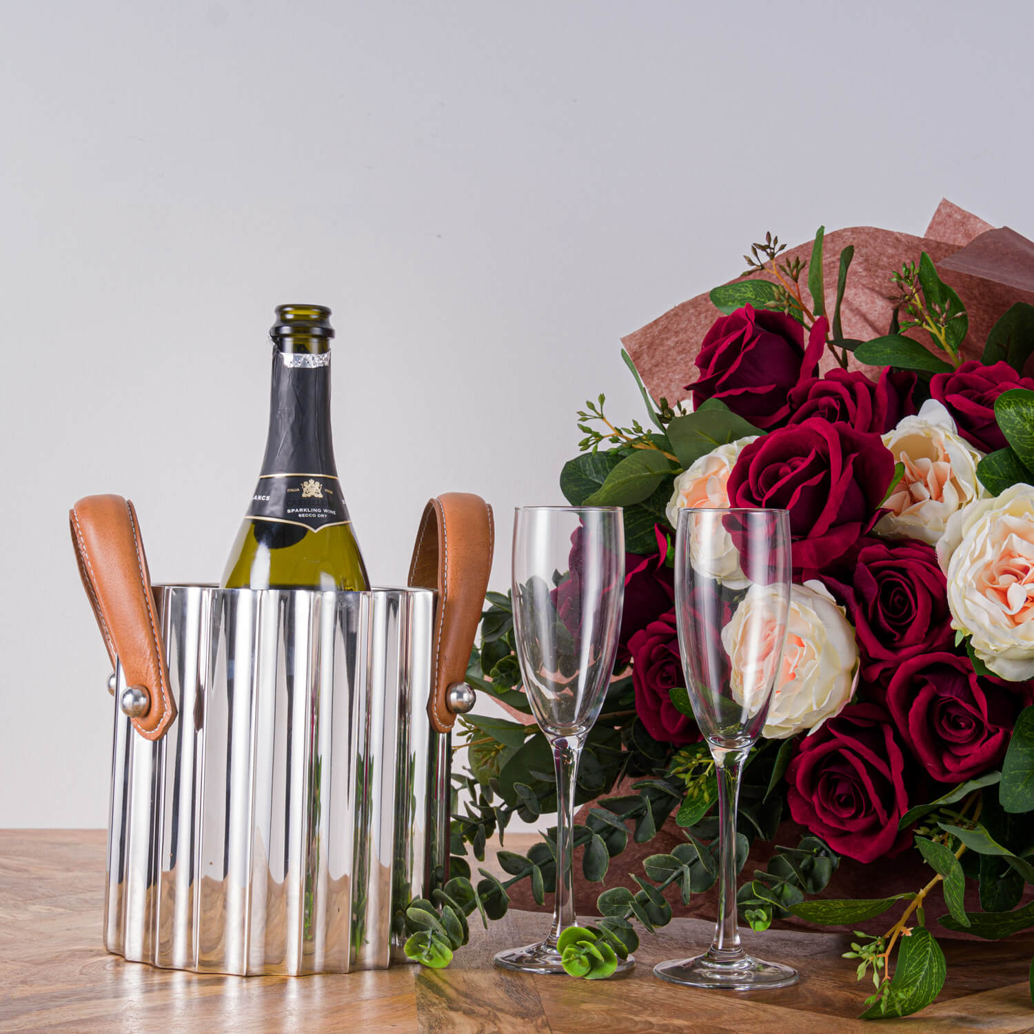Silver fluted champagne cooler with stainless steel body and leather handles, reflecting light elegantly. by RoomLondon at brixbailey.com