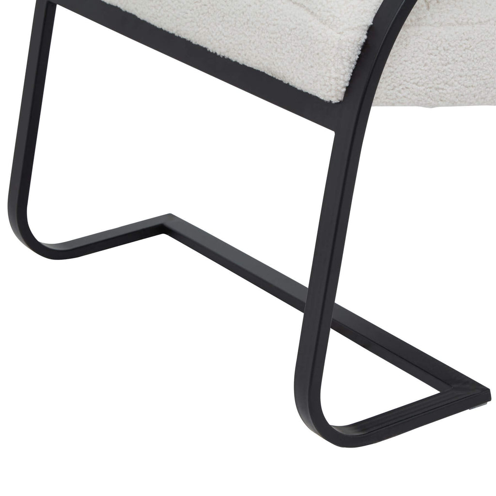 Cream boucle ribbed ark chair with curved black metal frame, channeled upholstery, and rocking motion for modern interiors by sostter at brixbailey.com