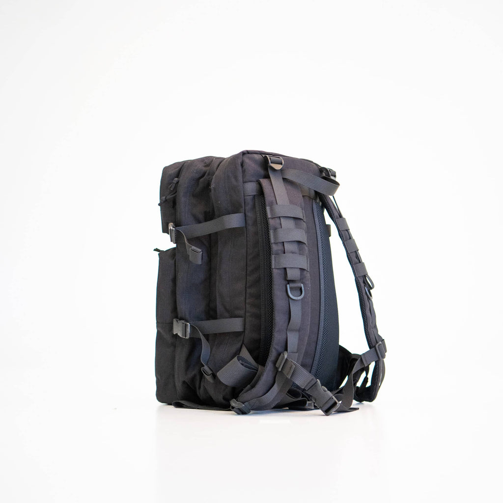 confident man adjusting the straps on his durable black cordura backpack for an adventure