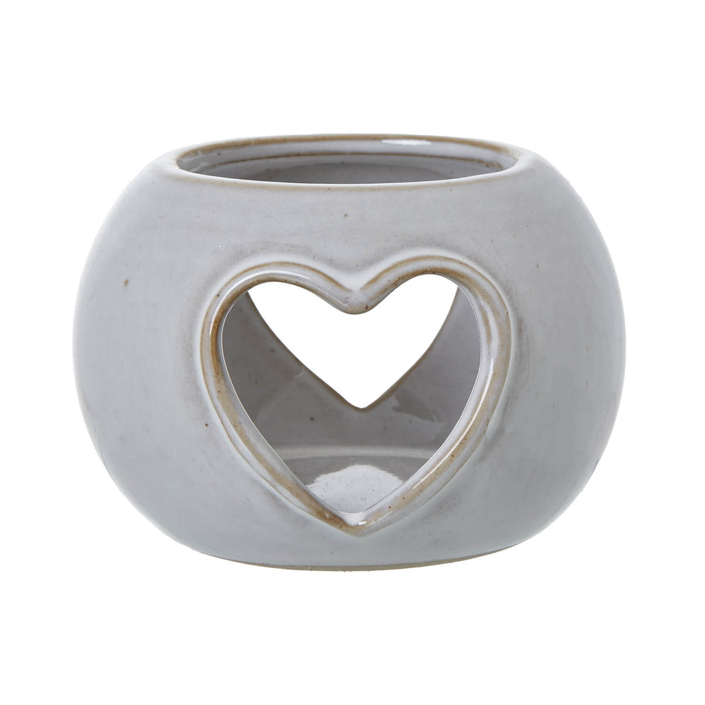 White ceramic tealight holder with heart-shaped cutouts, creating warm ambient light patterns for cozy decor by sostter at brixbailey.com
