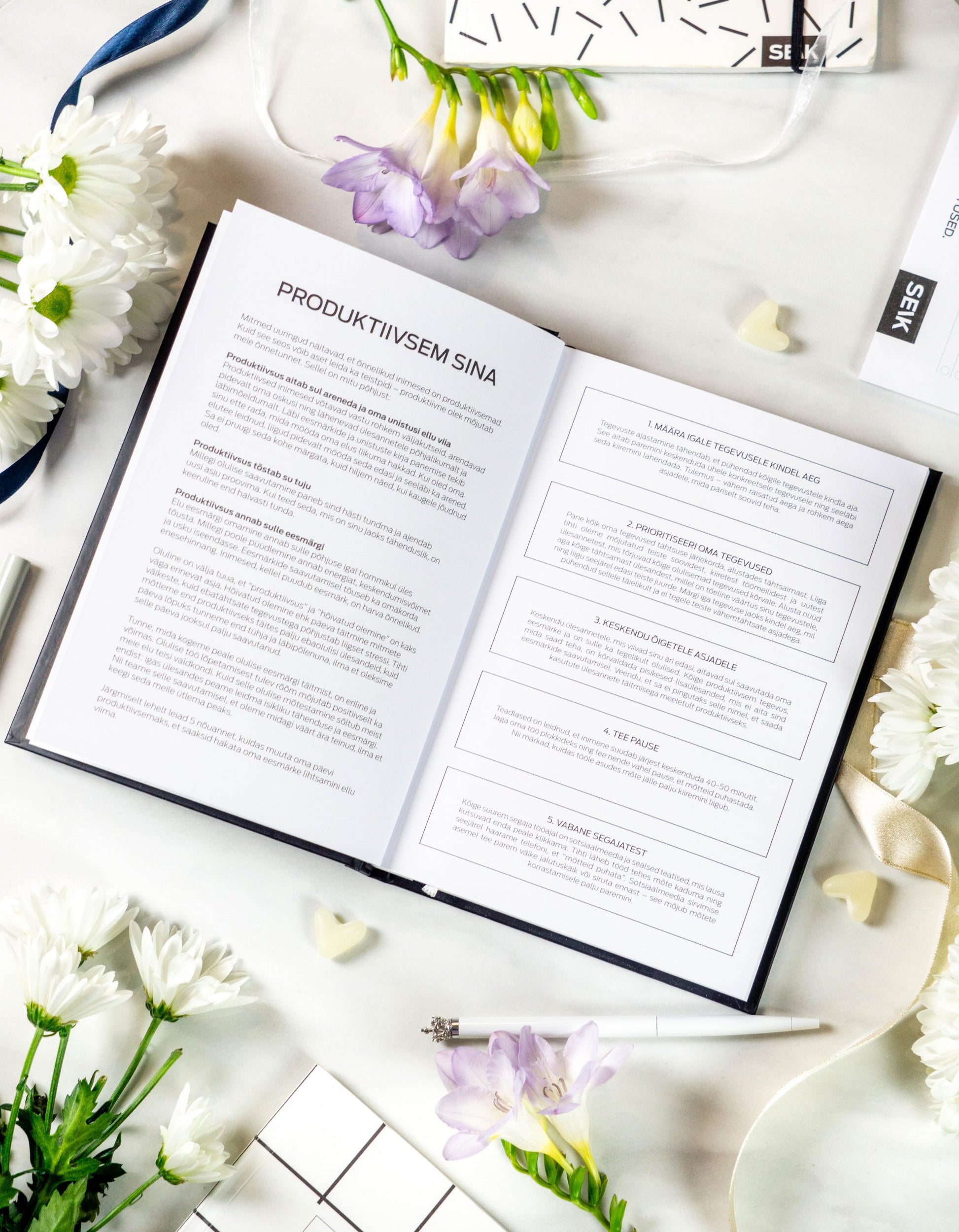 a functional productivity planner open on a desk with a pen, showing the weekly layout