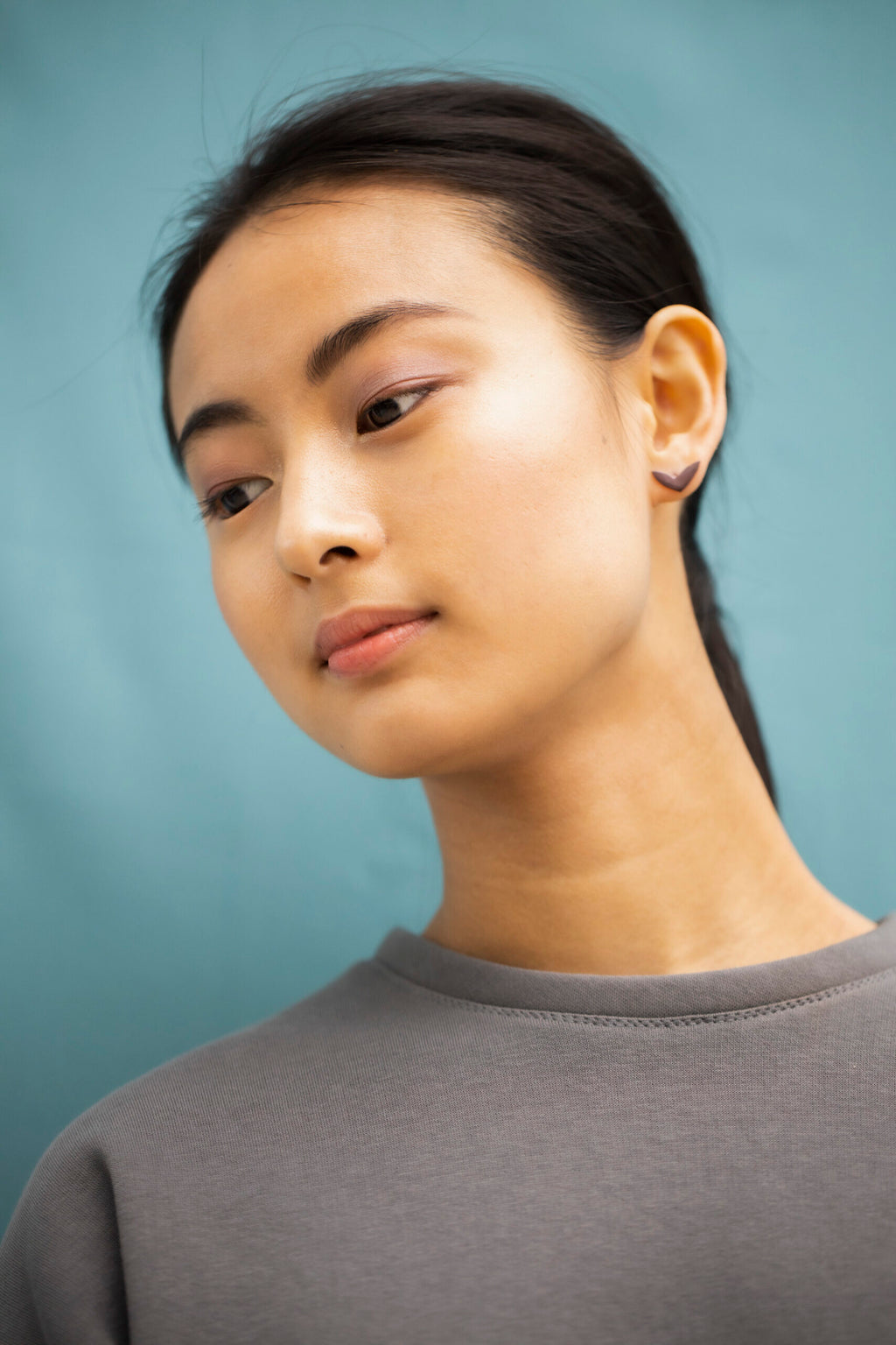 close-up of vola purple stainless steel earring on a dark background showing its polished surface and practical silicone stoppers