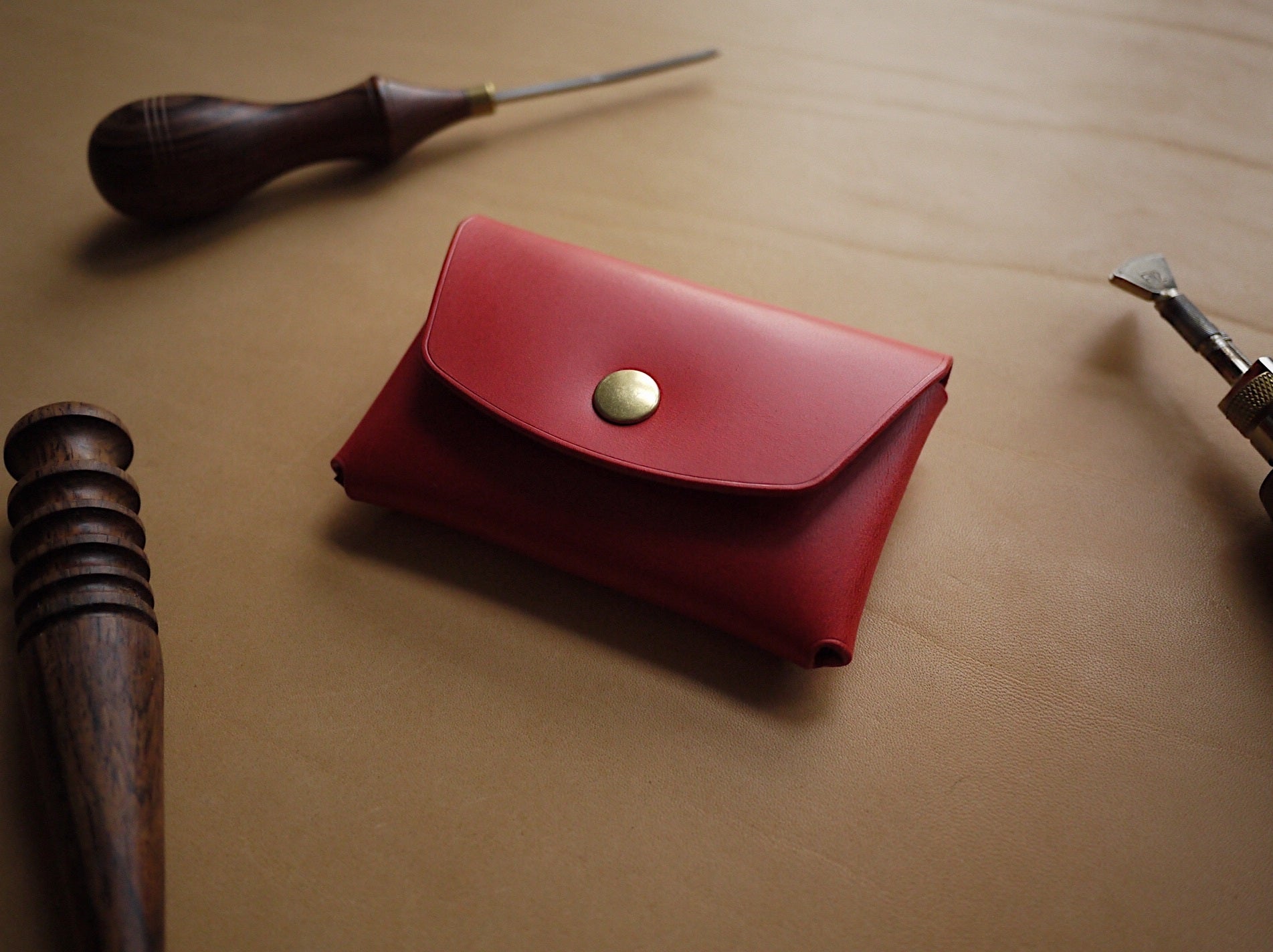 bold red handmade leather wallet open to show spacious card slots and polished edges