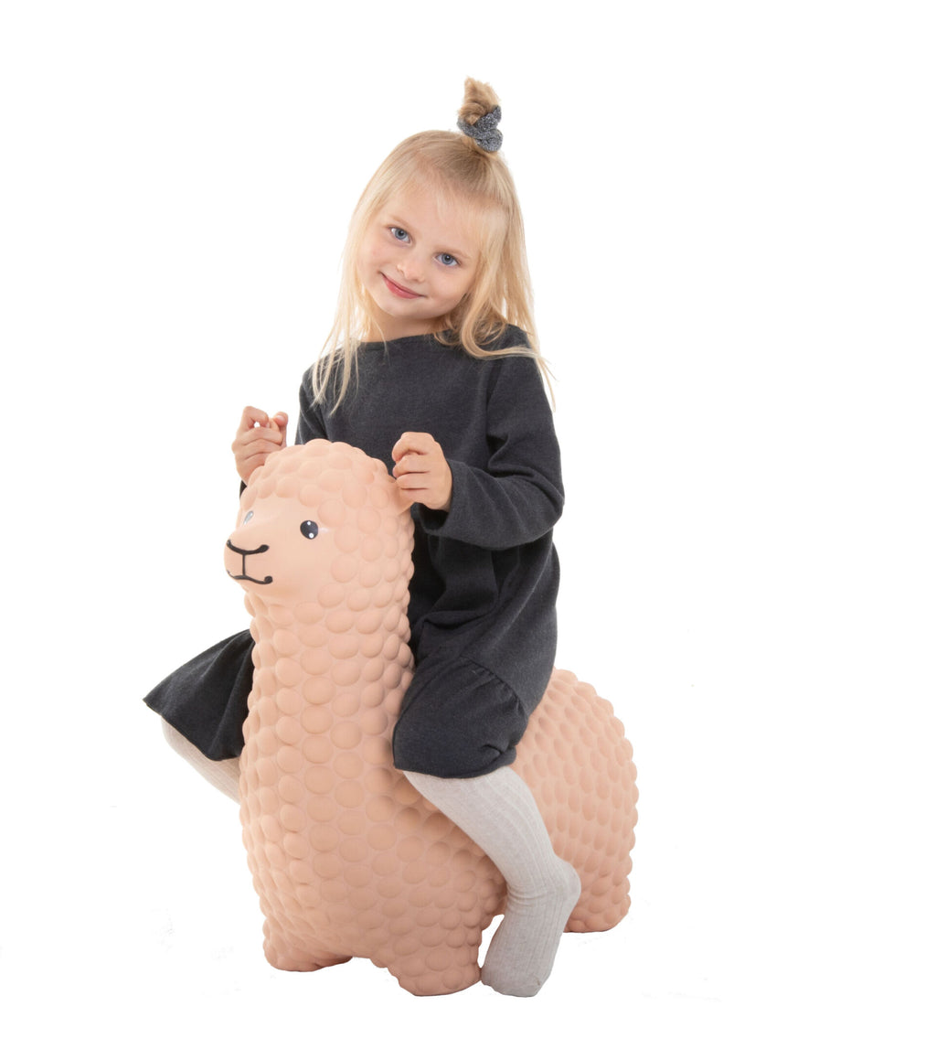 confident toddler on a beige alpaca jumpy hopper, ready for active indoor play