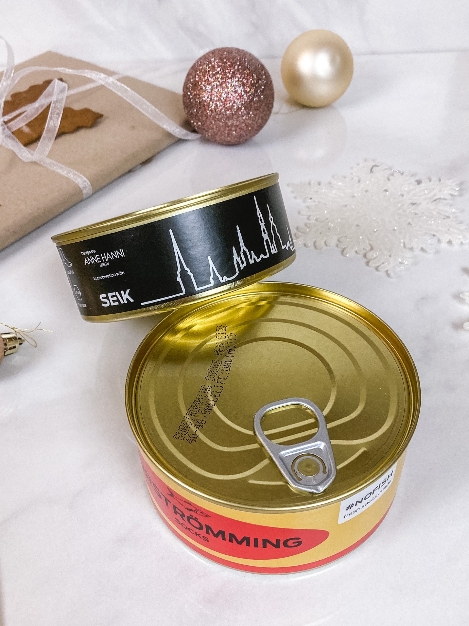 softly lit surströmming and tallinn tin can socks in a cozy gift box