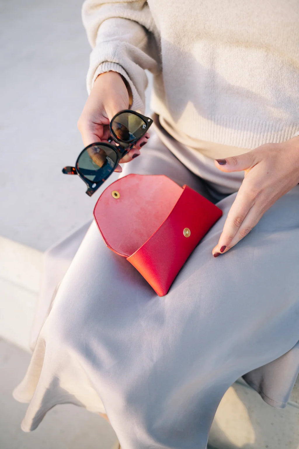 a bold close-up of a vibrant red leather sunglasses case on a dark background