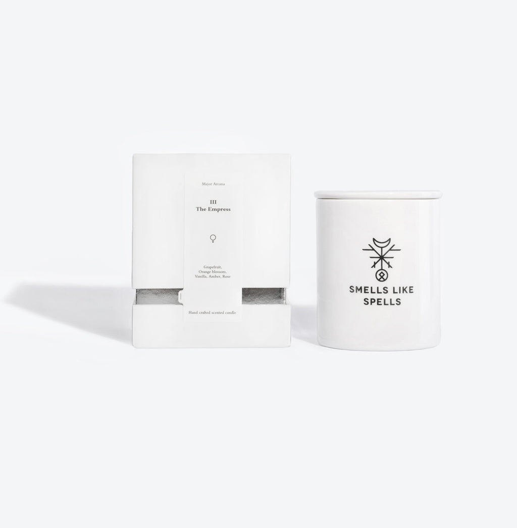 the empress tarot candle glowing elegantly in a soft-lit room with its hand-made porcelain container