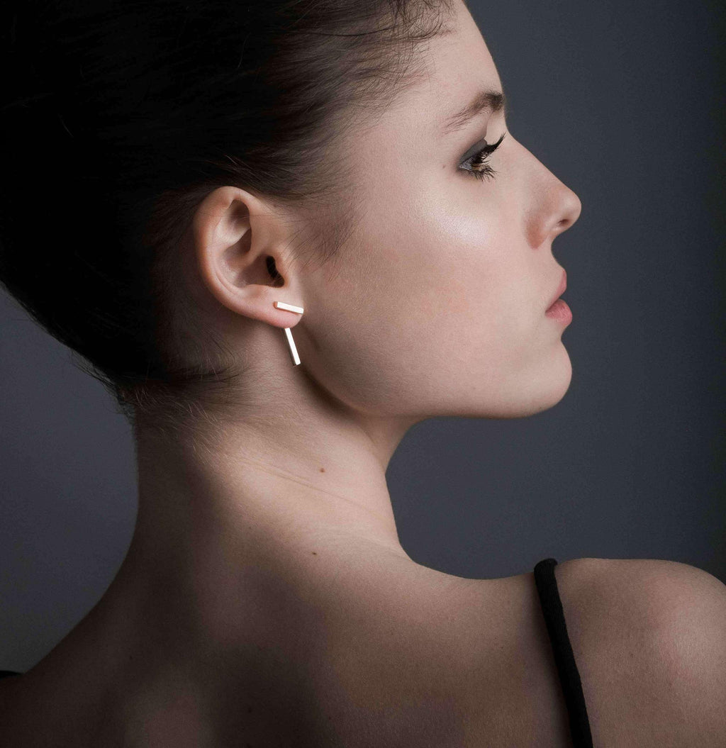 bold silver t-bar earrings close-up on a dark background, showcasing their sharp geometric angles and confident style
