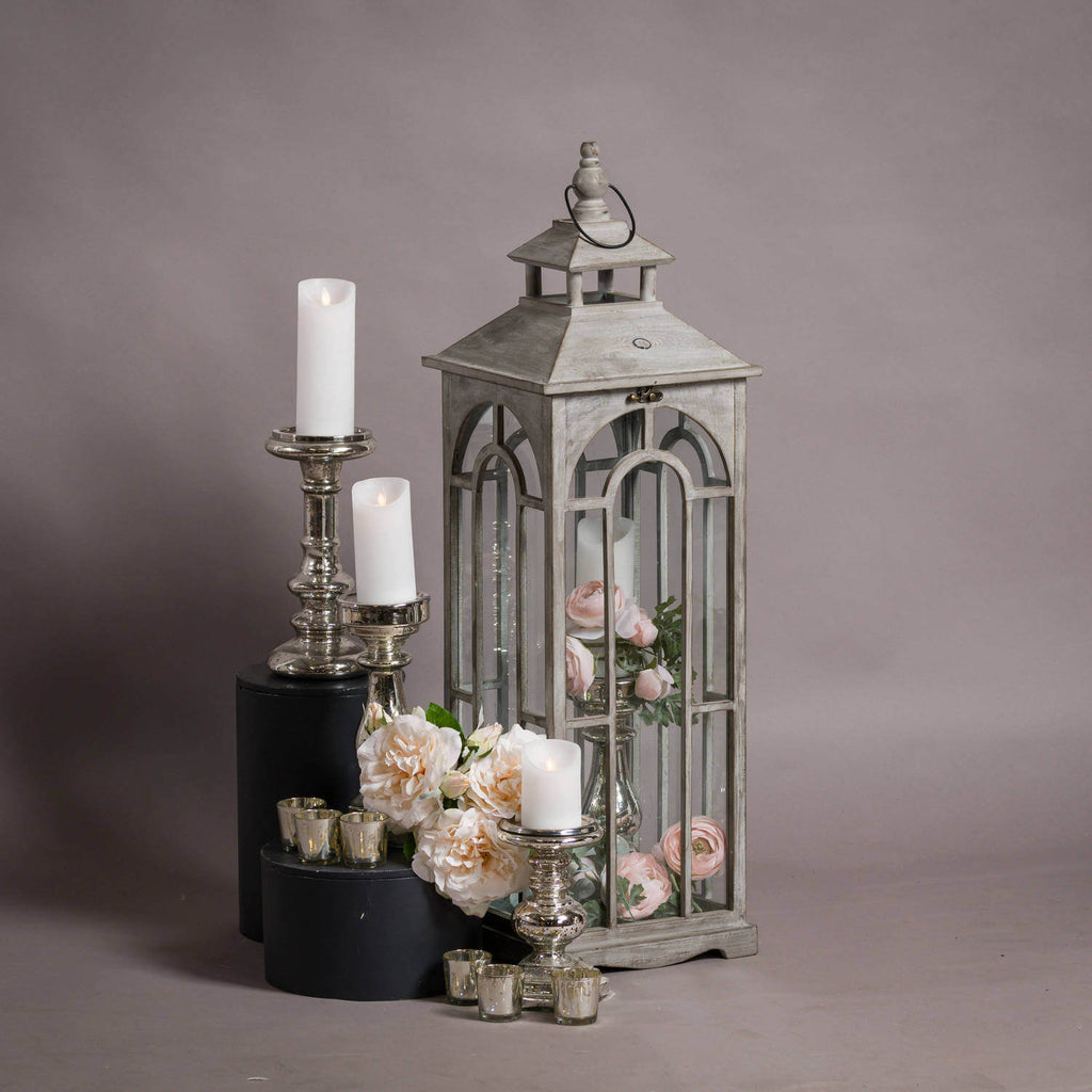 elegant white-wash wooden archway lantern in soft morning light, highlighting its artisanal brass clasps and refined grain