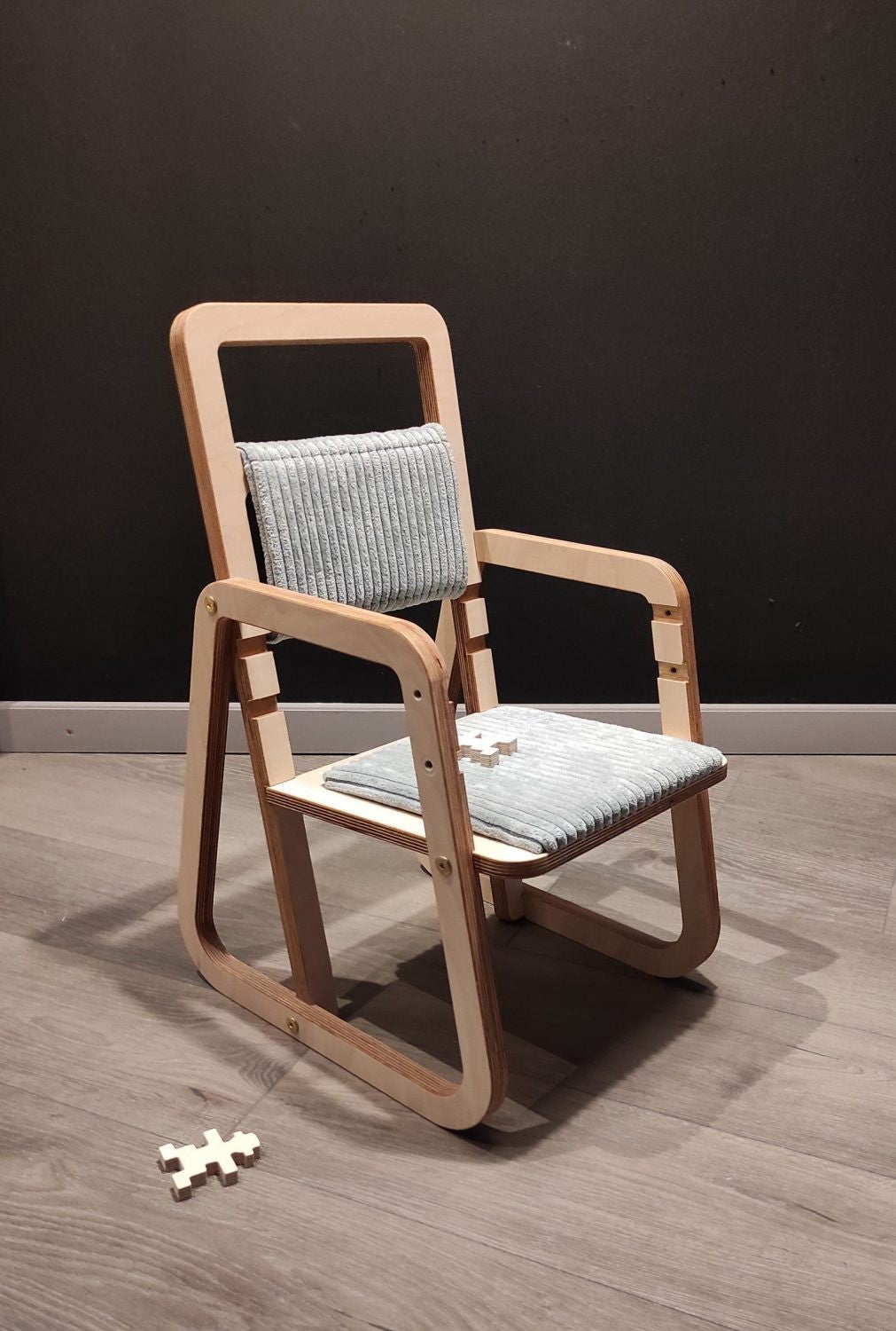 mint green julle kids chair showing the height adjustment mechanism in a bright, functional setting