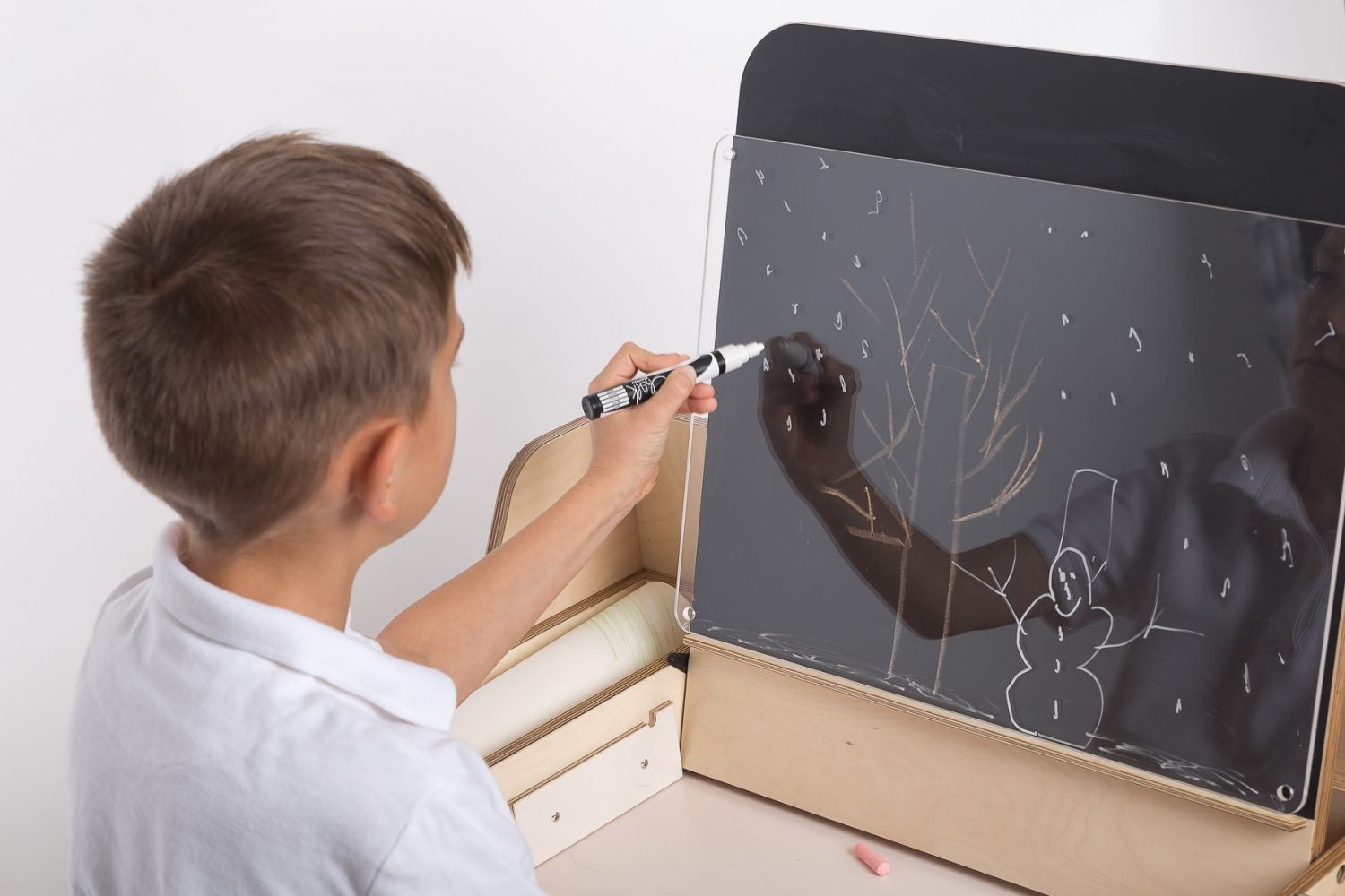 a close-up of the cannon pink montessori table's smooth white laminate and hidden storage compartments