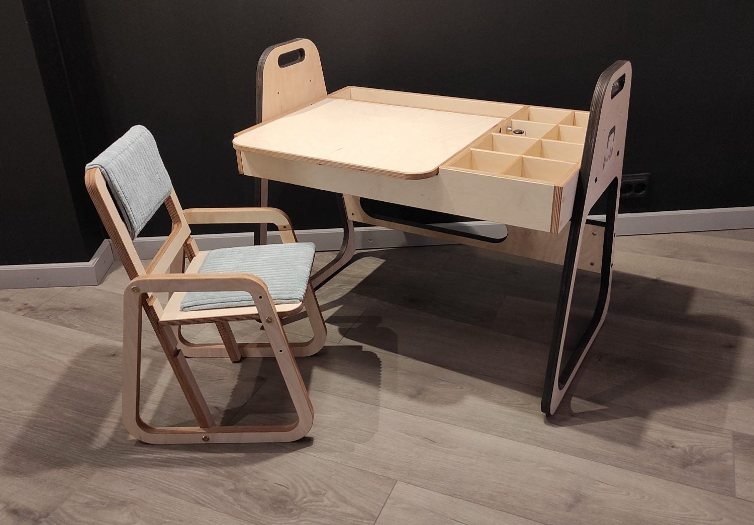 mint green kids art table with chalkboard and paper roll in a bright, sunlit playroom