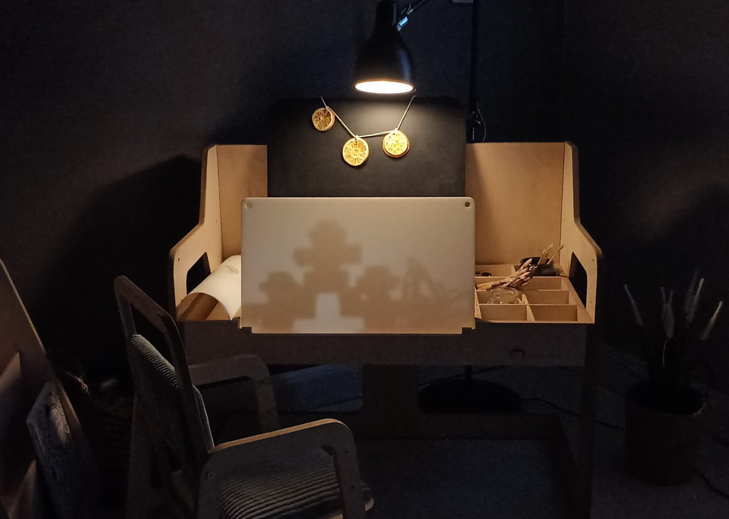 a child's hands drawing on the luula cannon pink table with art supplies visible in the open storage