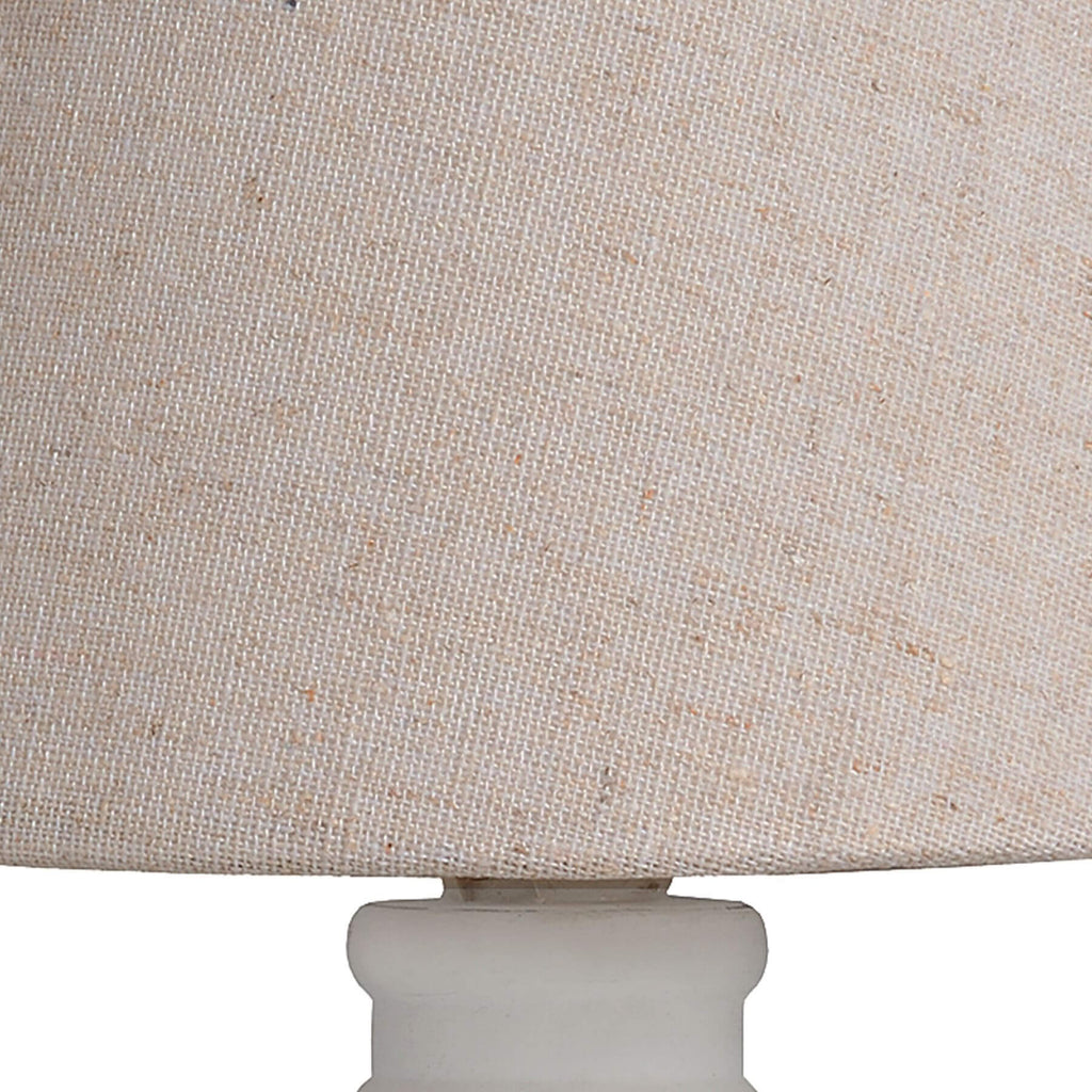 Handcrafted beige Cyrene table lamp with oatmeal shade and white wooden base for warm, elegant lighting. by Sostter at brixbailey.com