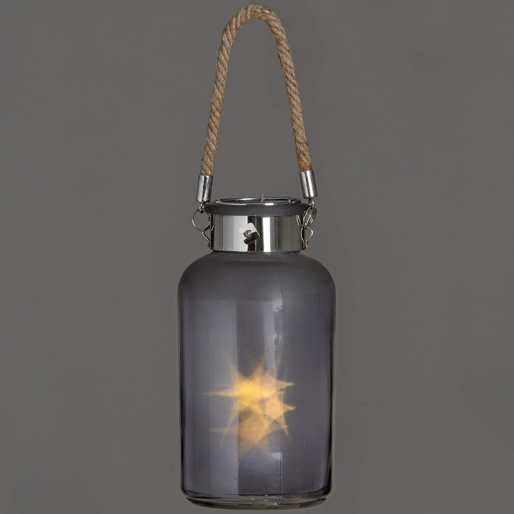 Frosted grey glass lantern with LED starlight glow, rope handle, and rustic modern design for indoor or outdoor ambiance by sostter at brixbailey.com