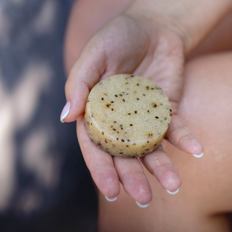 elegant kiwi seed scrub bar with visible exfoliants and lemongrass aroma, presented on a minimalist background