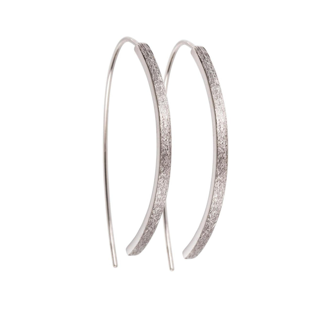 bold close-up of elegant small arch earrings with brushed silver texture and polished interior edge