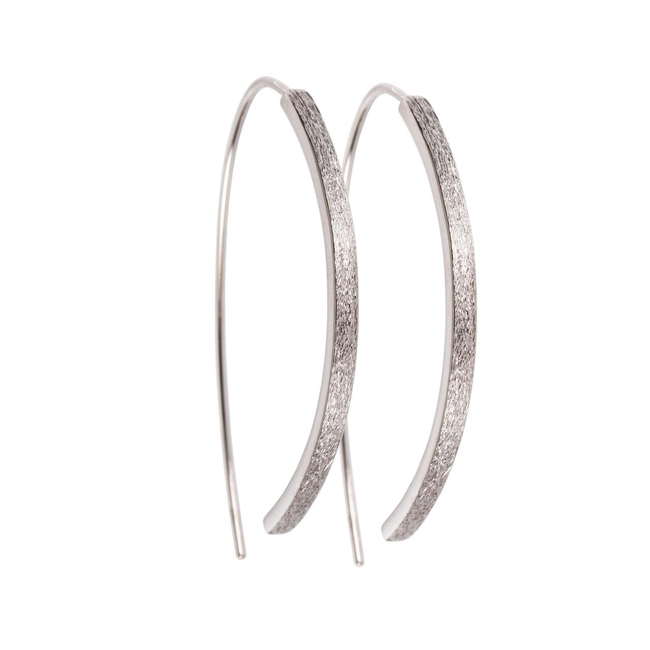 bold close-up of elegant small arch earrings with brushed silver texture and polished interior edge