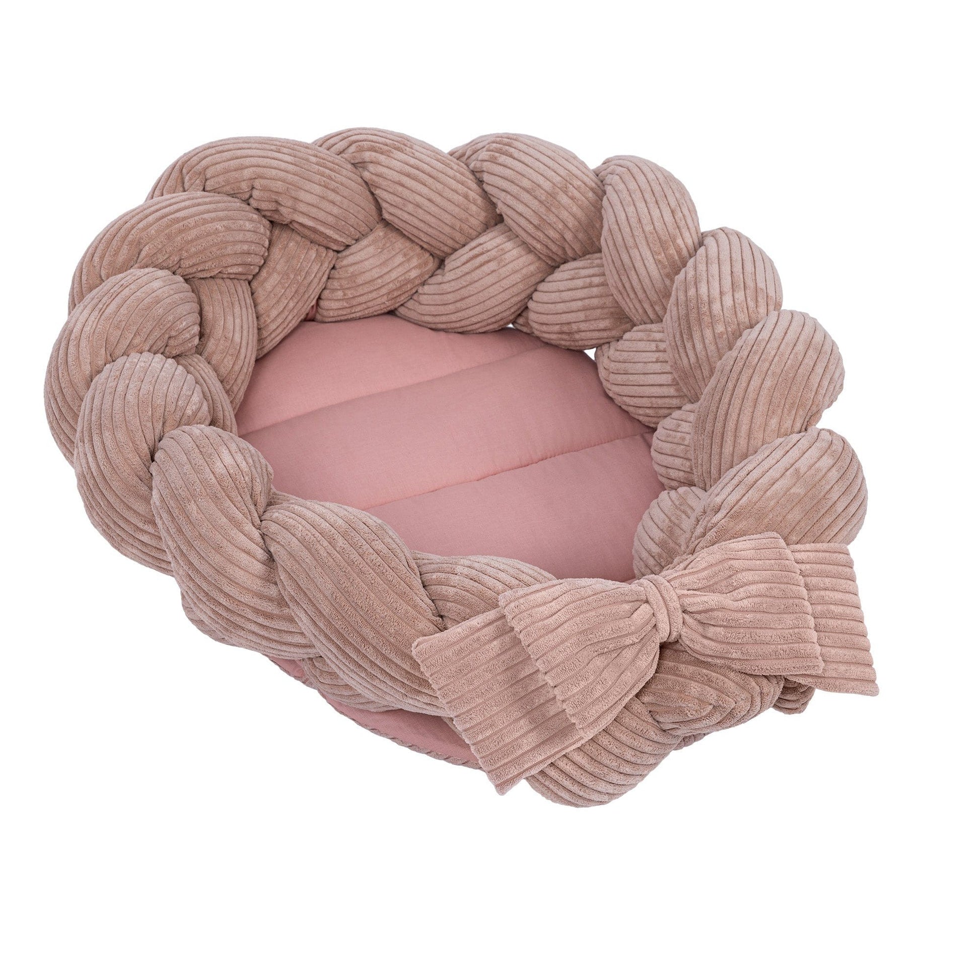 bold powder pink baby nest with a statement braided bumper in warm morning light