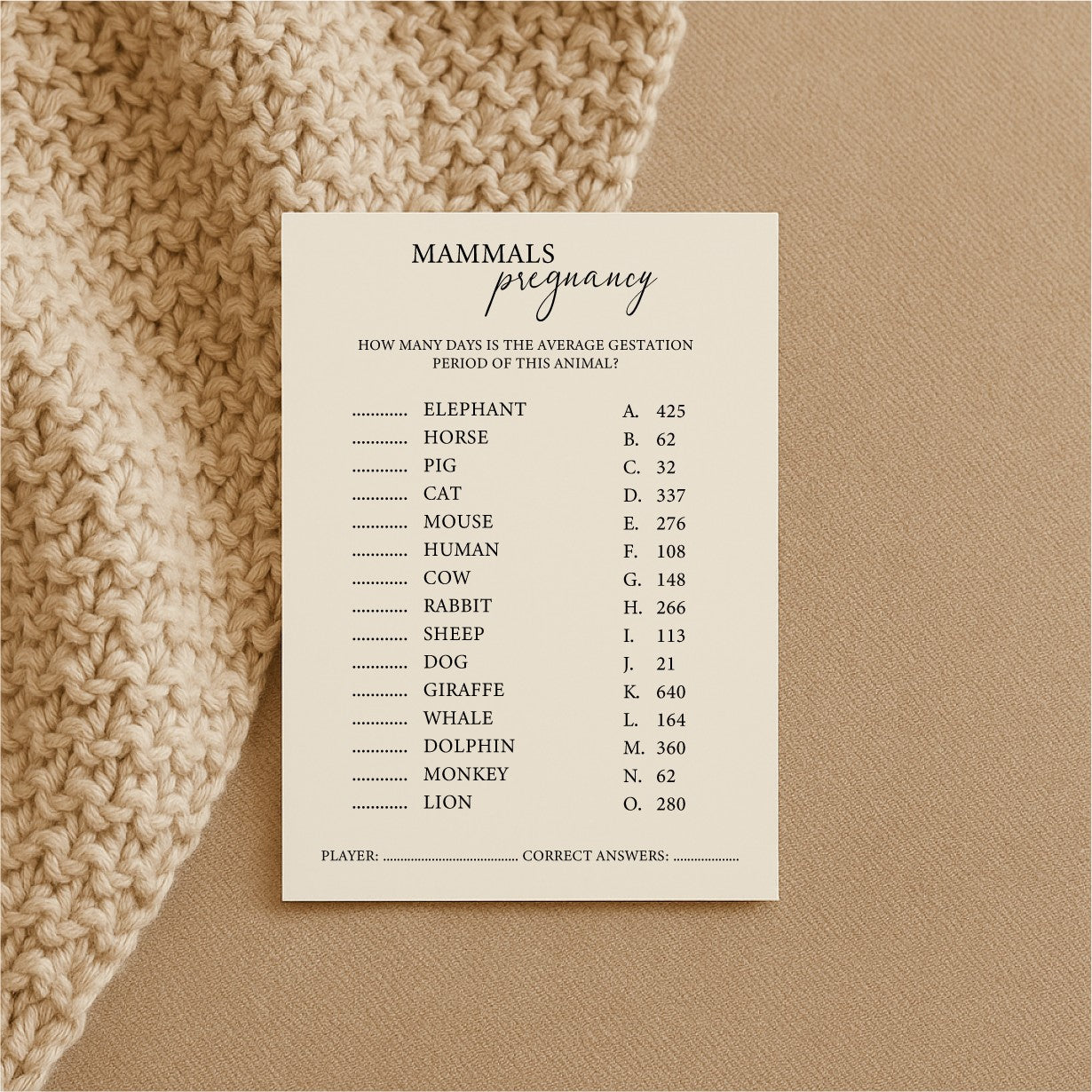 a bold close-up of a baby shower trivia card on luxurious cream cardstock, revealing a quirky mammal fact