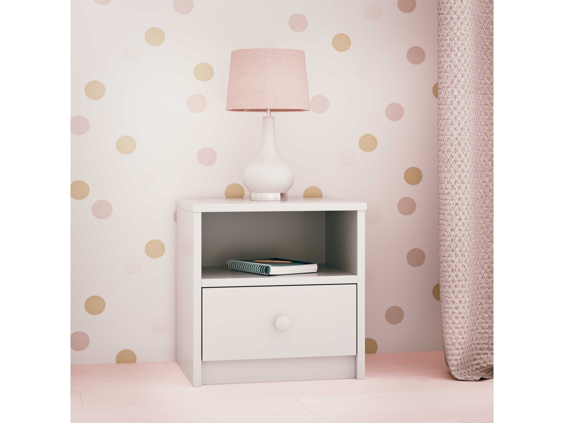a soft pink babydreams bedside table with an open shelf and drawer in a cozy, softly lit nursery