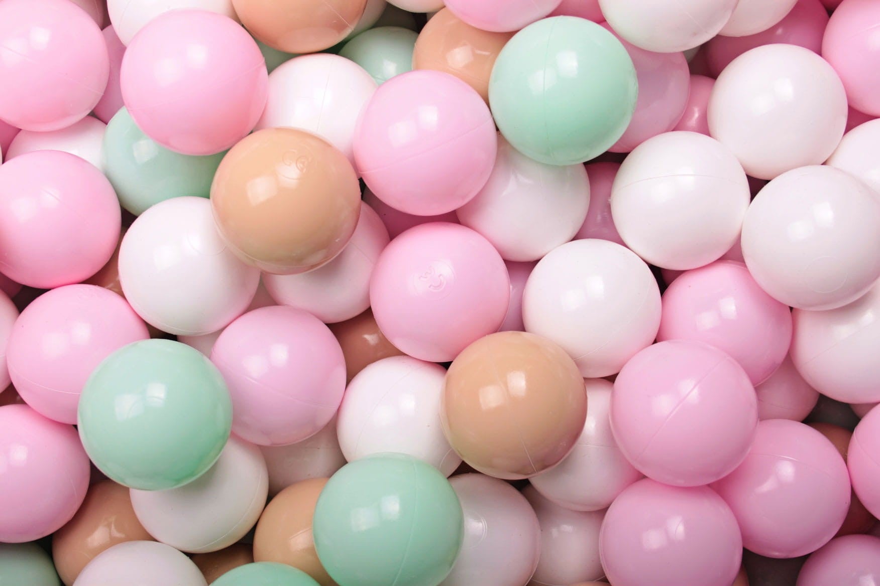 bold overhead shot of 200 beige mint white and pink ball pit balls for sensory play