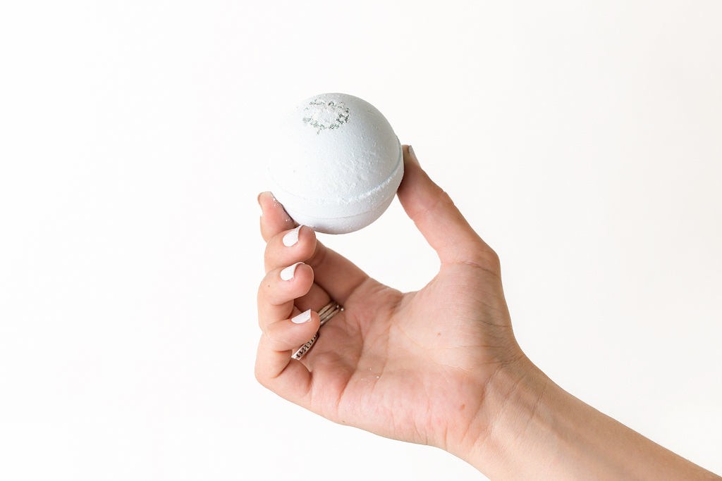 softly lit trio of natural bath bombs in an elegant gift box, a comforting self-care gift