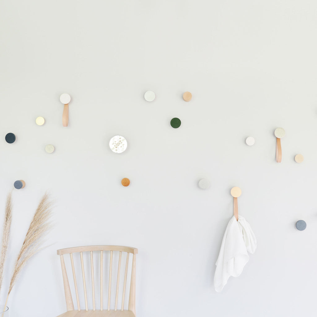 playful white sand ceramic and beech wood hook on a bright yellow wall