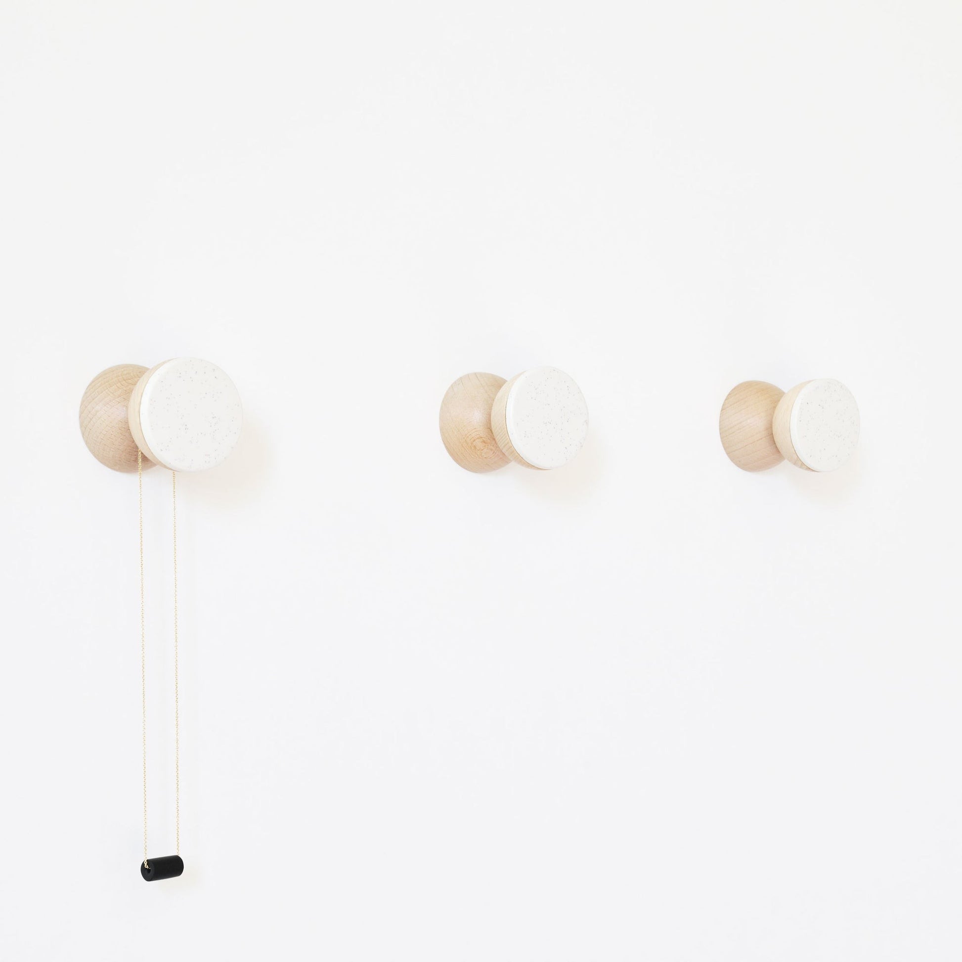 bold modern white sand ceramic and beech wood wall hook on a clean minimalist background