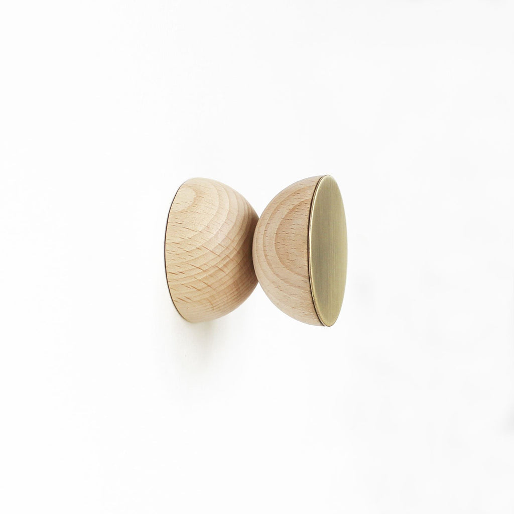 soft-lit beech wood and brass wall hook casting a warm, comforting glow on a rustic wall