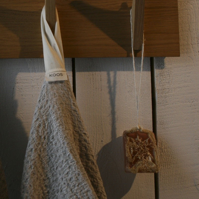 elegant oversized grey linen bath towel draped gracefully in soft, refined light