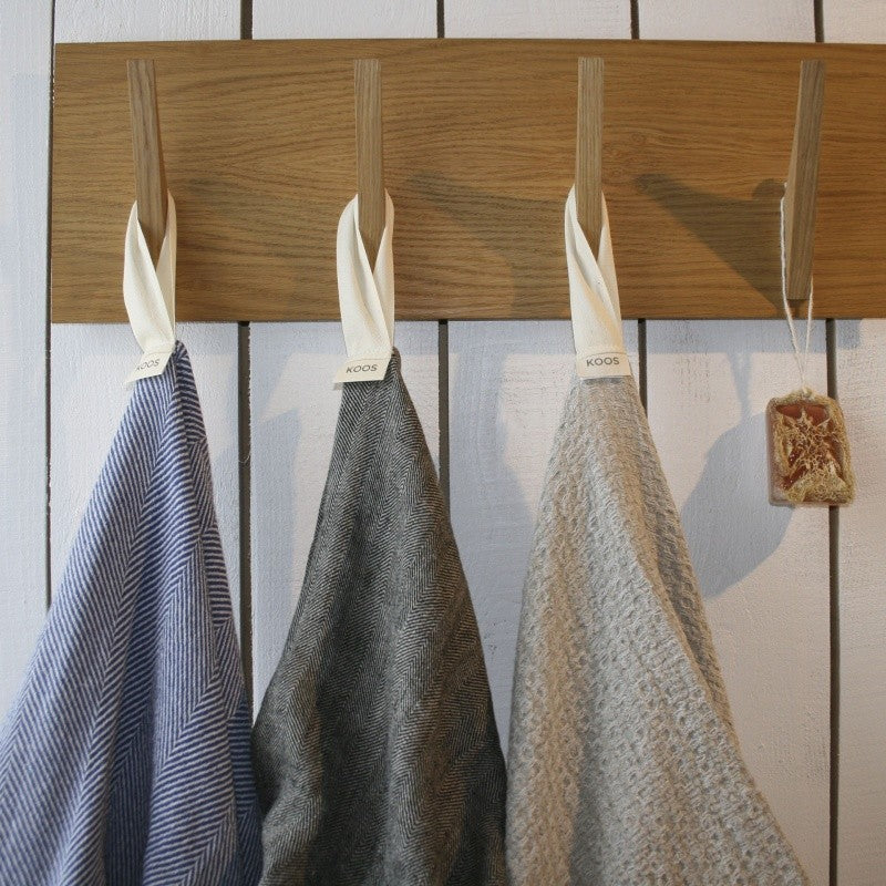 a bold, oversized grey linen bath towel displayed with dramatic studio lighting