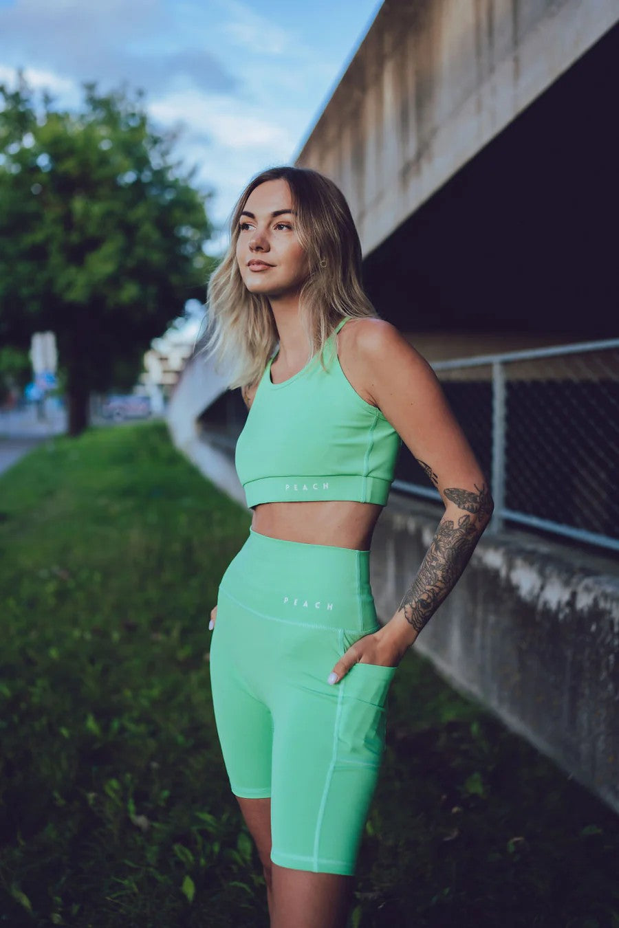 confident woman in sage green high-waisted biker shorts with side pockets