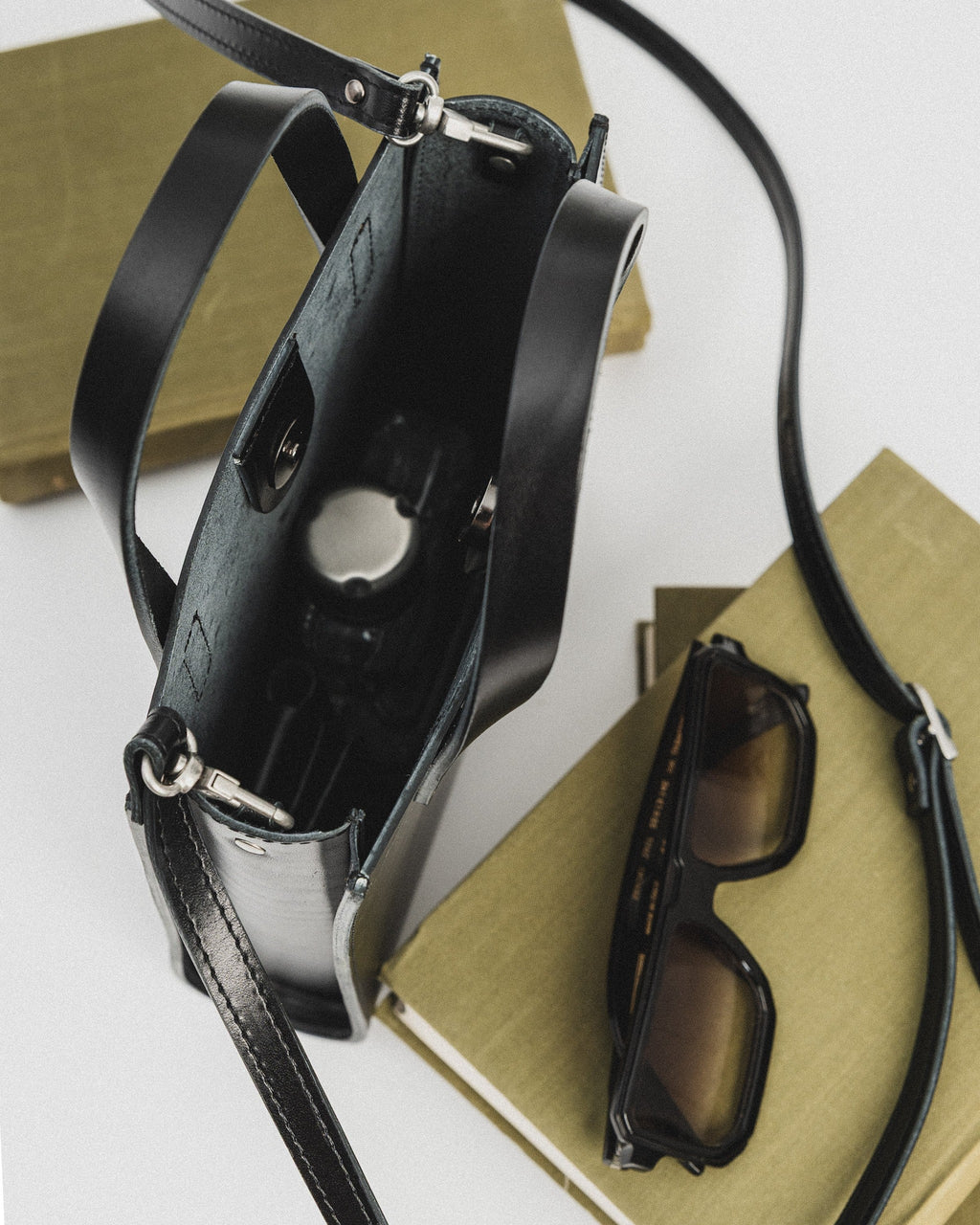 playful black bucket handbag worn crossbody on a sunny day