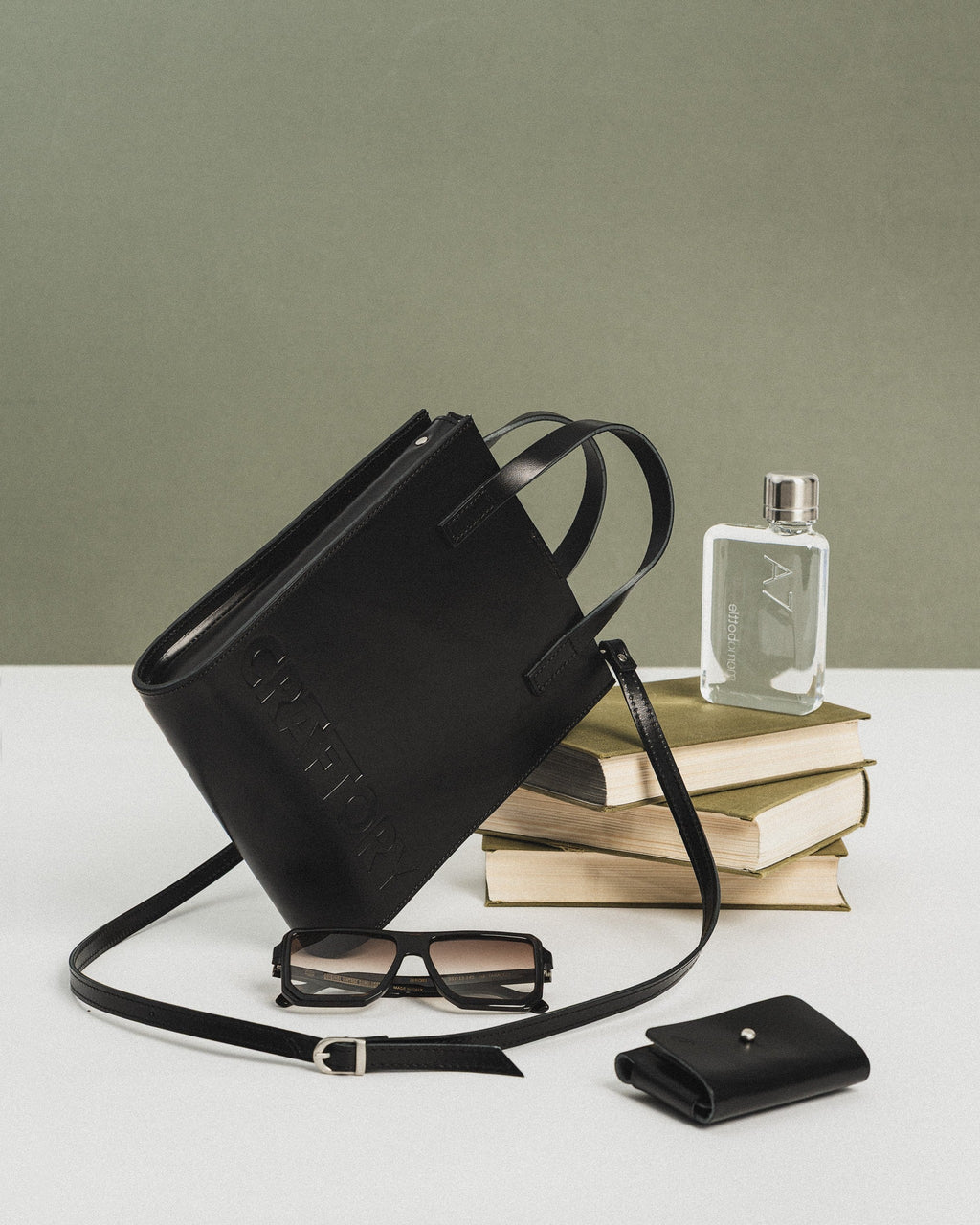 black bucket handbag with adjustable strap shown open on a table